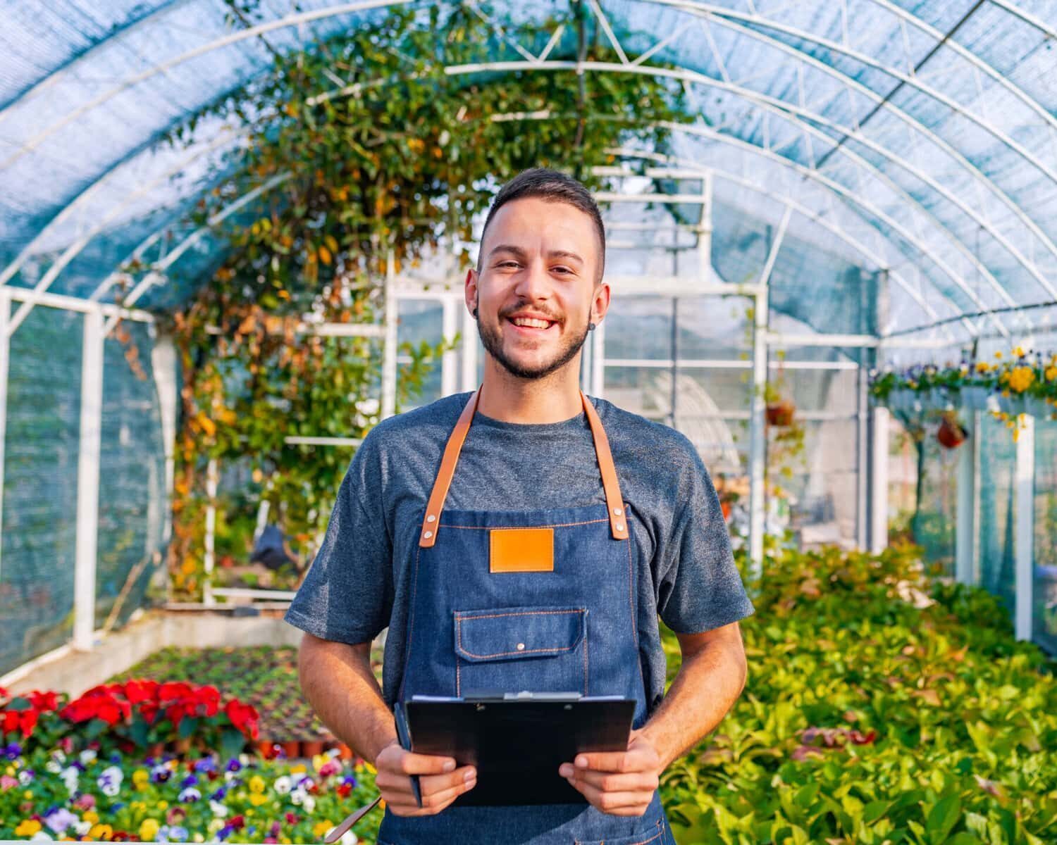 Adviseur controleert de gezondheid en groei van planten in een kas